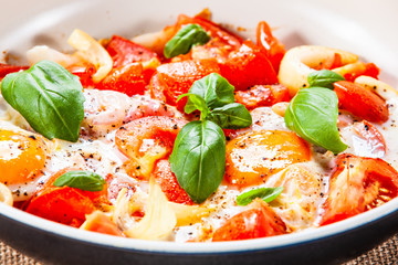 Shakshuka - fried eggs with vegetables in frying pan