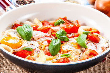Shakshuka - fried eggs with vegetables in frying pan