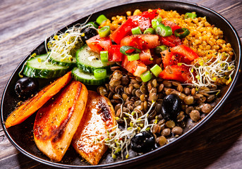 Groats with lentils and vegetables on wooden table