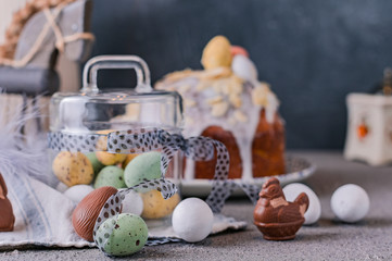 Easter orthodox sweet bread, kulich and colorful quail eggs with willow branches. Holidays breakfast concept with copy space. Retro style.