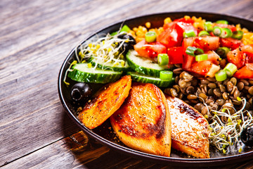 Groats with lentils and vegetables on wooden table