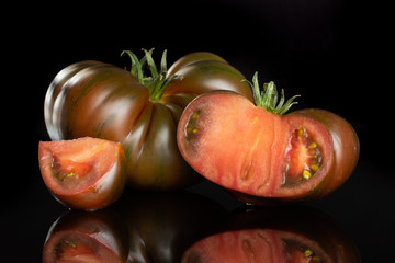 Fototapeta na wymiar Group of one whole one half one slice of fresh tomato primora isolated on black glass