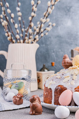 Easter orthodox sweet bread, kulich and colorful quail eggs with willow branches. Holidays breakfast concept with copy space. Retro style.