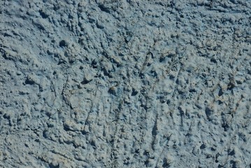 gray stone text from stucco on concrete old wall