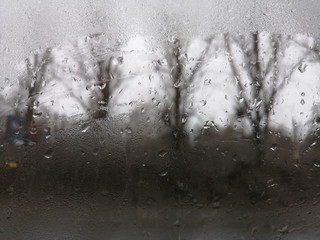 Texture of dripping drops on window closeup in spring in March