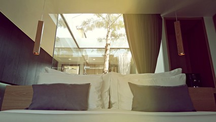 stylish bedroom interior design with white striped pillows on bed and decorative curtain.