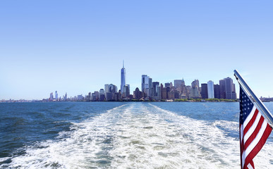 Lower Manhattan view from cruise ship or yacht with the flag of the United States of America in New...