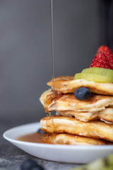 Chef pouring honey on pancakes