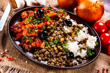 Rice with lentils and vegetables on wooden table