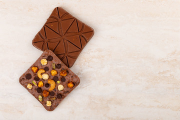 Top view of craft chocolate bars on beige marble background with copy space