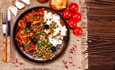 Rice with lentils and vegetables on wooden table