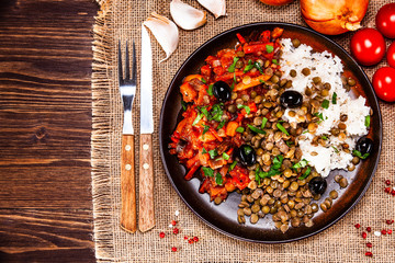 Rice with lentils and vegetables on wooden table