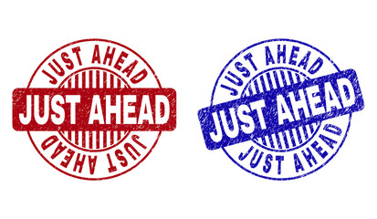 Grunge JUST AHEAD round stamp seals isolated on a white background. Round seals with grunge texture in red and blue colors. Vector rubber watermark of JUST AHEAD title inside circle form with stripes.