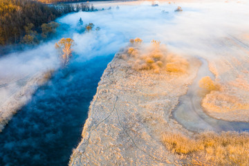 Foggy landscape. River on frosty morning aerial. Hoarfrost on grass top view
