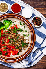 Rice with lentils and vegetables on wooden table