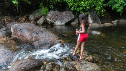 Young girl feeding fish by the river