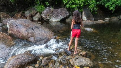 Young girl feeding fish by the river