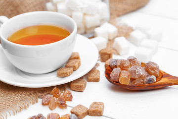 Glass cup of hot tea with sugar on the table