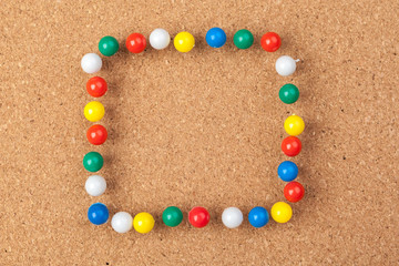 Group of thumbtacks pinned on corkboard