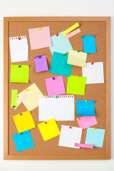 Cork board with several colorful blank notes with pins