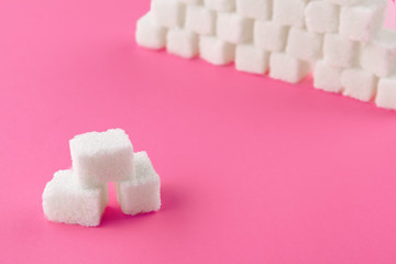 Cubes of sugar on a pink background. Empty space for copying text