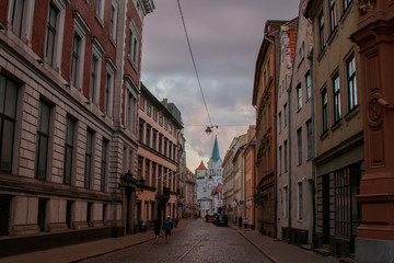 Street in the old town of Riga, leading to the white Church. At sunset.