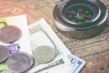 compass and money on a wooden table