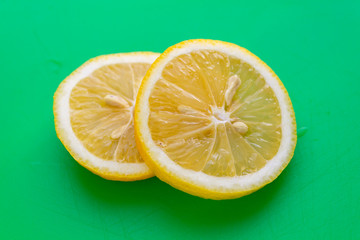 sliced lemon on green background 