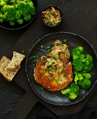 Fried pork steak with broccoli and onion sauce.