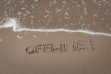 Fototapeta premium The word “offline” written in the sand symbolizing a time-out