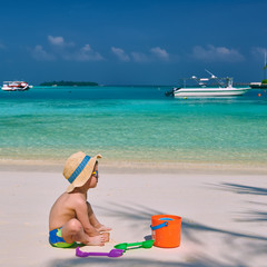 Three year old toddler playing on beach