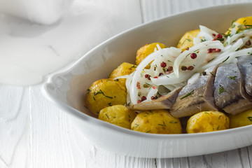 Herring with fried potatoes and onion on a plate