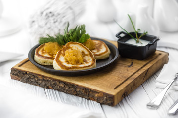 Hot tasty baked pancakes with red caviar