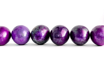 Easter eggs decorated in different shades of violet lined on isolated white background. Close-up.