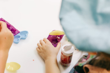 hands of a child, a master class in cooking chocolate, folding fruit and chocolate into molds