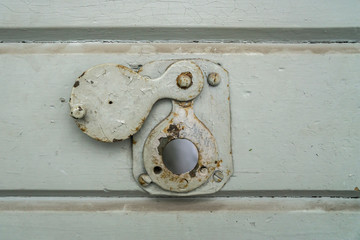 Close up of a peep hole in grunge metal the door of an old prison.