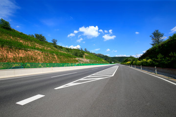 Fototapeta premium Highway, under the background of blue sky and white clouds
