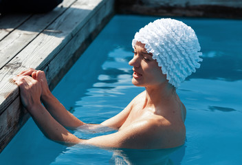 Beautiful young nude woman in swimming pool