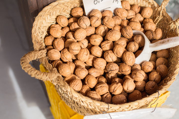 Closeup of collecting walnuts in a wicker handmade basket for sale.