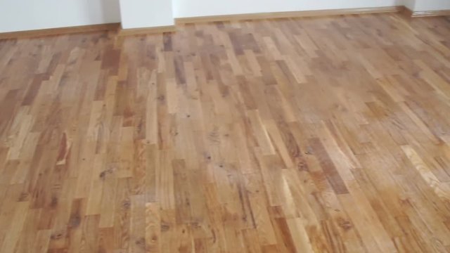 Shallow depth of field wood surface. The camera moves along the modern parquet floor