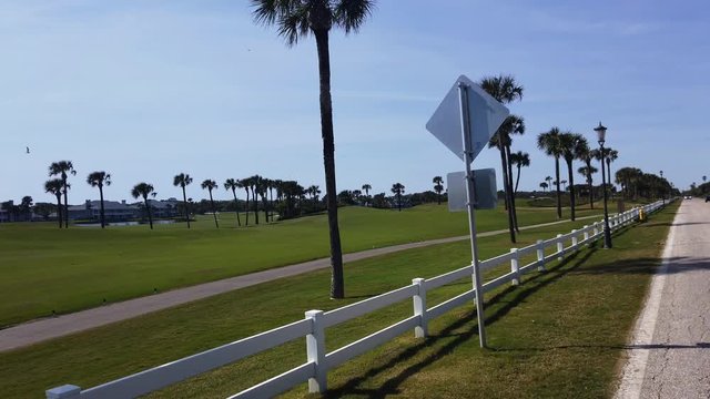 A rear driving view of an upscale Florida golf course.