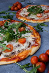 Homemade pizza with rucola and cherry tomatoes.