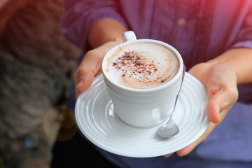 lady serving hot chocolate topping with foam in the white cup in the morning with copy space