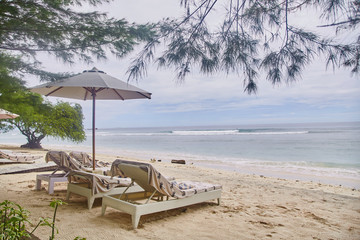 Sun beds with umbrellas on the Bali beach