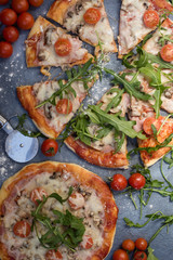 Sliced pizza with arugula and cherry tomatoes.