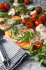 Homemade pizza with rucola and cherry tomatoes.