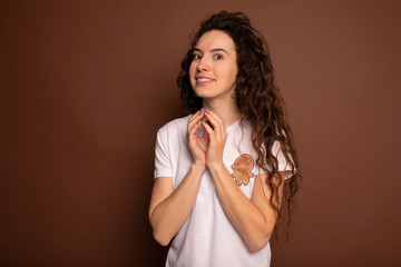 Portrait of sly, scheming woman plotting something isolated on brown background. Negative human emotions, facial expressions, feelings, attitude. Woman in white t-shirt