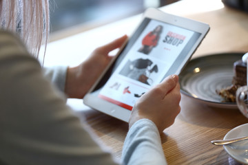 Young woman shopping online in cafe, closeup