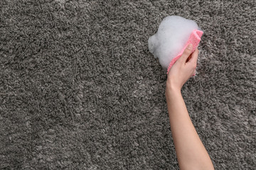 Woman cleaning carpet at home