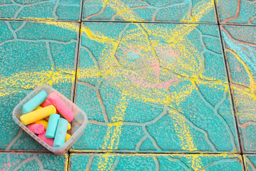 Painted sun. Children's drawing with colored chalk on the tile. Close-up. Background. Texture.